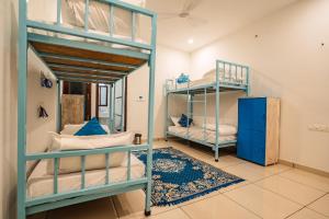 a room with two bunk beds and a rug at Hachi Hostel Jaisalmer in Jaisalmer