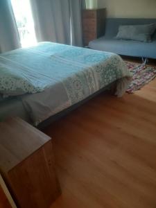 a bedroom with a bed and a wooden floor at Casa en la playa con piscina in Guanaquero