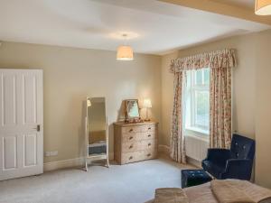 a bedroom with a dresser and a window at Aspen Grove Lodge in Sutton +16 photos