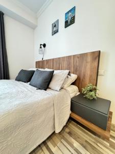 a bedroom with a large bed with a wooden headboard at EVIS LTD apartments Gudauri in Gudauri