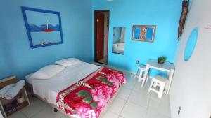 a blue bedroom with a bed and a table and chairs at Pousada casa nostra in Piúma +31 photos