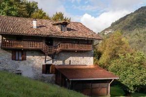 an old house with wooden balconies on a hill at Wooden Stories - Nature, Netflix & Wi-Fi in Socchieve