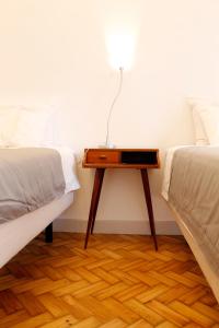 ein Schlafzimmer mit einem Tisch zwischen zwei Betten in der Unterkunft Casa da Catedral in Porto