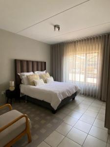a bedroom with a large bed and a window at Yanaz Place in Germiston
