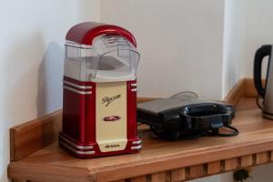 a red mixer sitting on a wooden shelf at Wooden Stories - Nature, Netflix & Wi-Fi in Socchieve