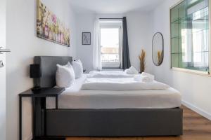 布雷根茨homy Lakeside Symphony in Bregenz am Bodensee的一间卧室，里面有一张铺着白色床单的大床。