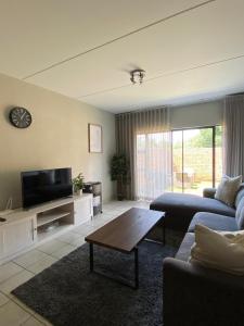 a living room with a couch and a tv at Yanaz Place in Germiston