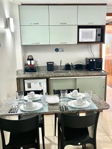a kitchen with a table with plates and glasses on it at Flat JP Beira mar in João Pessoa