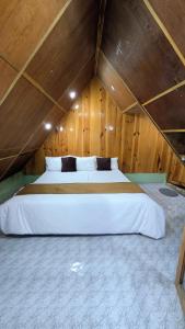 una camera da letto con un grande letto in una camera in legno di Accomoon River Side Cottages a Dirang Dzong