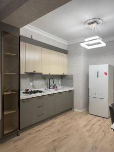 a kitchen with white appliances and a white refrigerator at Levent beach Luxury apartment in Sumqayıt