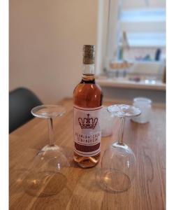 a bottle of wine and two wine glasses on a table at Ferienhaus Sandseele in Fehmarn