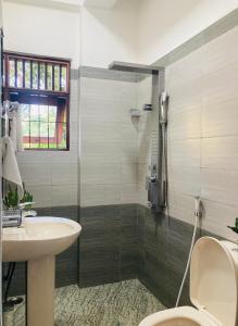 a bathroom with a toilet and a sink and a shower at OHASA Home stay in Gampaha