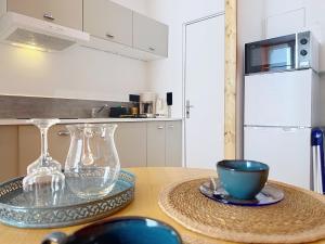 a kitchen with a wooden table with a bowl and glasses on it at Teeny Ponta Plage in Royan