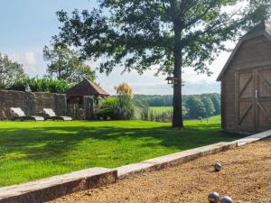 a yard with a tree and a woodenshed at La Belle vue in Durbuy