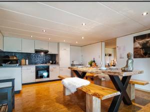 a large kitchen with a wooden table and a bench at La Belle vue in Durbuy