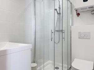 a white bathroom with a shower and a toilet at Teeny Ponta Plage in Royan +13 photos