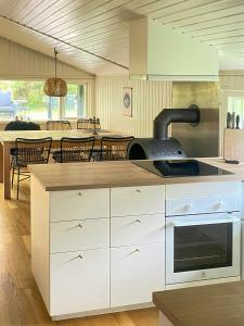 a kitchen with white cabinets and a stove top oven at Holiday Home Near Fjerritslev With Fenced Garden in Fjerritslev