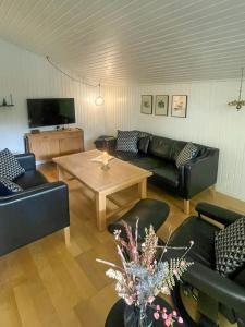 a living room with couches and a table at Holiday Home Near Fjerritslev With Fenced Garden in Fjerritslev