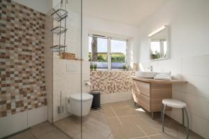 Un baño con ducha, inodoro y lavabo. en Kugelhaus Phoebe Charmantes Kugelhaus aus Holz am Waldrand des Tollensesees, en Wustrow 28 fotos más