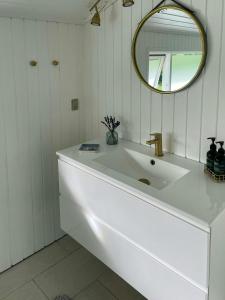 a white bathroom with a sink and a mirror at Holiday Home Near Fjerritslev With Fenced Garden in Fjerritslev