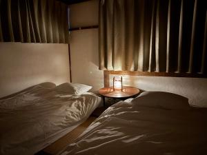 a bedroom with two beds and a table with a candle at Vineyard Vista ENZAN in Koshu +48 photos