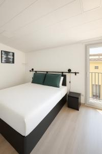 a bedroom with a large white bed and a window at 3-Story Gaudi Building with Montserrat Stone in Monistrol