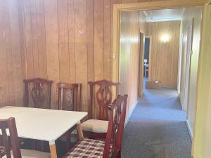 a dining room with a table and chairs and a hallway at Cozy Queen Room Close to Shops and Station - PH4 in Pendle Hills +1 photo