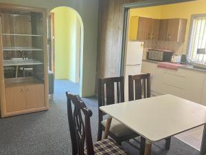 a kitchen with a table and chairs in a room at Cozy Queen Room Close to Shops and Station - PH4 in Pendle Hills