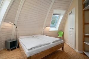 a bedroom with a bed in an attic at Kugelhaus Eos - Sonnengeküsstes Ferienhaus in organischer Bauweise am Seeufer in Wustrow