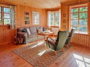 a living room with a couch and a table at Charming Cottage Near The Sea On Rossö in Nyckleby