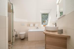 a white bathroom with a sink and a toilet at Kugelhaus Solveig - Zeitloses Holzhaus in Kugelform für stille Momente in der Natur in Wustrow +28 photos