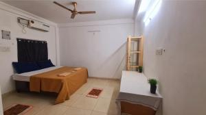 a room with a bed and a table in it at SPIDEY's PITSTOP in Auroville