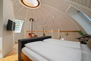 a bedroom with a large bed with a round ceiling at Kugelhaus Kugellager - Besonderer Rückzugsort in runder Bauweise - reduziert, ruhig und naturnah am Tollensesee in Wustrow