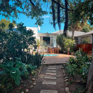 a garden with a pathway leading to a house at Aquarius Bed and Breakfast in Jeffreys Bay