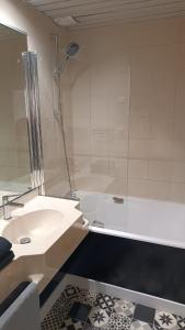un bagno con lavandino e vasca da bagno di Le WORLD, studio 3 minutes from Futuroscope a Chasseneuil-du-Poitou Altre 4 foto