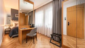 a hotel room with a desk and a bed at Flatbook - City Center SPA Apartments Deo Plaza Studio II in Gdańsk