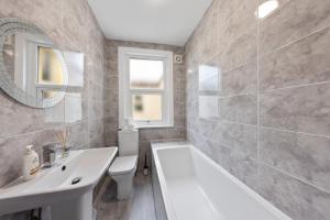 a bathroom with a white tub and a sink at modern 4 bdr house rock ave in Gillingham