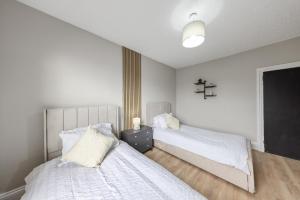 a bedroom with two beds and a cross on the wall at modern 4 bdr house rock ave in Gillingham +43 photos