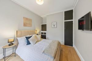 a bedroom with a bed and a table with a lamp at modern 4 bdr house rock ave in Gillingham