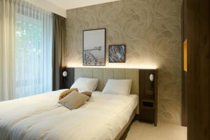 a bedroom with a large bed with a teddy bear on it at Droomsuites Texel 4 personen by Droomvilla in Den Burg