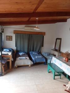 a living room with three beds and a table at Quinta in Villa Constitución
