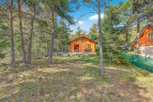 a wooden cabin in the woods with trees at Chalet Le Mazet in Les Prats