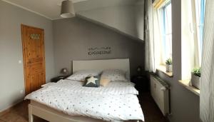 a bedroom with a bed with a white comforter at Ferienwohnung Möwe in Glowe