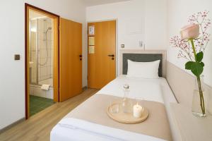 une chambre avec un lit avec deux bougies dessus dans l'établissement Hotel Daucher, à Nuremberg