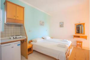 a small room with two beds and a kitchen at Nidri view Apartments in Nydri