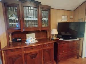 a room with a wooden cabinet with a television and a desk at Il Borghetto in Villaretto