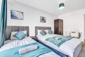 two beds sitting next to each other in a bedroom at Charming Deritend Apartment with Full Access for Wheelchairs in Birmingham +2 photos