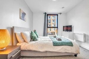 a bedroom with a bed and a couch and a tv at Charming Deritend Apartment with Full Access for Wheelchairs in Birmingham