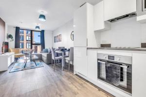 a kitchen and living room with a couch and a table at Charming Deritend Apartment with Full Access for Wheelchairs in Birmingham