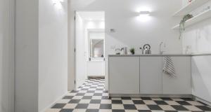 - une cuisine blanche avec un sol en damier noir et blanc dans l'établissement JOIVY Elegant Studio in the Centre of Milan, à Milan